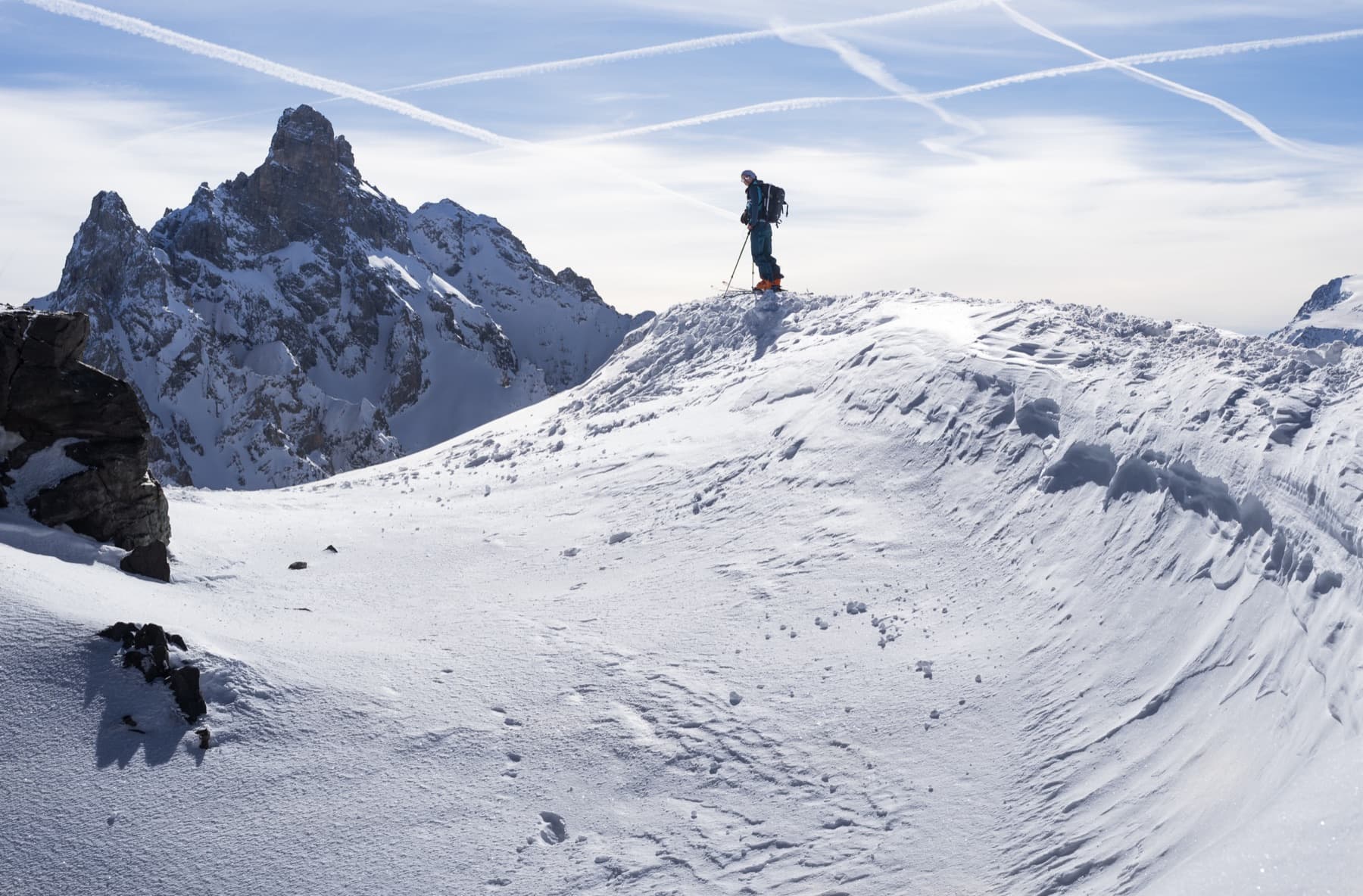 A single track through untouched powder among snow-covered firs